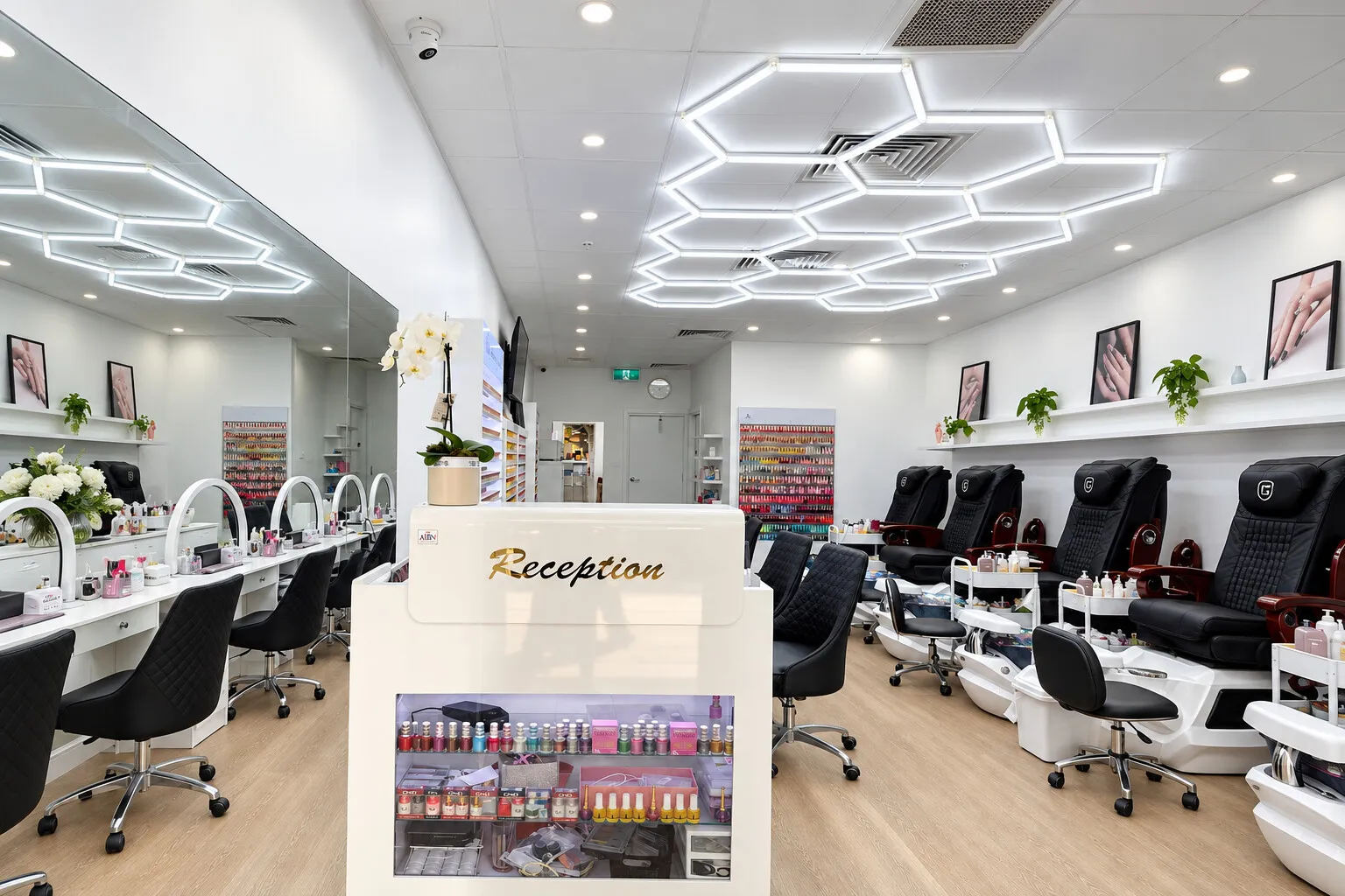 The reception desk at Brighton Beauty Studio, with white orchids on the counter and the nail stations behind it